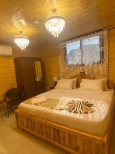 a bedroom with a large bed with two chandeliers at كوخ خزامى الباحة in Al Baha