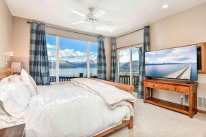 a bedroom with a bed and a flat screen tv at Majestic Summit Retreat: Family Vacation Rental Overlooking Lake Pend Oreille in Lignite
