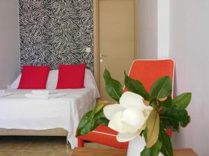 a room with a bed and two red chairs and a plant at Aeolis Apartments & Studios in Apidias Lakos