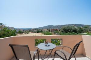 a patio with a table and chairs on a balcony at Villa Clotho in Porto Rafti