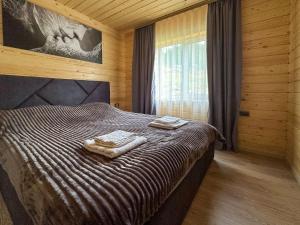 a bedroom with a bed with two towels on it at Котедж Forest house in Verkhovyna