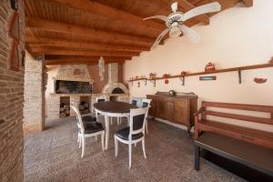a dining room with a table and chairs and a ceiling fan at Villa Clotho in Porto Rafti