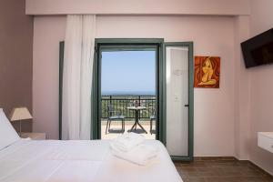 ein Schlafzimmer mit Bett und Blick auf einen Balkon in der Unterkunft Villa Kyveli in Loutra + 49 Fotos