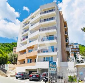 a building with cars parked in front of it at Boljevic Apartments in Bečići