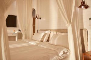 法拉尔雅Lov Faralya Adults Only的房间里有一张铺着白色床单和枕头的床