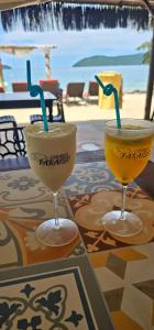 two drinks on a table with a view of the beach at Pousada Cabanas Paraiso in Angra dos Reis +20 photos