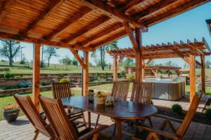 a patio with a wooden pergola and a table and chairs at Ruralna kuća za odmor - Bitunjac in Levanjska Varoš