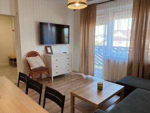 a living room with a television and a table and chairs at Pokoje Gościnne REST in Karwia