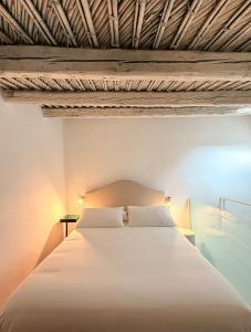 une chambre avec un grand lit blanc avec deux lampes dans l'établissement CoDe24, à Noto