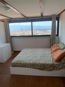 a bedroom with a bed and a large window at luxury ciccy apartment in Reggio di Calabria