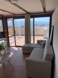 a living room with a couch and a large window at luxury ciccy apartment in Reggio di Calabria
