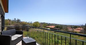 einen Balkon mit Sofa und Blick auf einen Hügel in der Unterkunft Casa Pimenta in Fajã da Ovelha in Prazeres