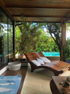 a porch with a wooden bench on a patio at Beautiful house overlooking the sea, swimming pool and Wi-Fi in Angra dos Reis