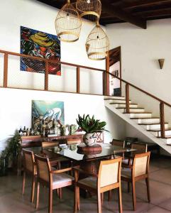 a dining room with a table and chairs and a staircase at Beautiful house overlooking the sea, swimming pool and Wi-Fi in Angra dos Reis