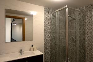 ein Badezimmer mit Dusche, Waschbecken und Spiegel in der Unterkunft Casa Pimenta in Fajã da Ovelha in Prazeres + 17 Fotos