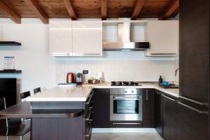 a kitchen with white cabinets and a stove top oven at La Colonghera by Quokka 360 - flat on Lake Como in Carate Urio +32 photos