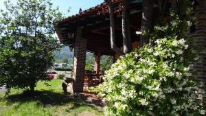 a house with white flowers on the side of it at Hotel El Bricial in Soto de Cangas