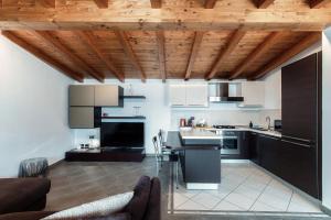 a kitchen with white cabinets and a wooden ceiling at La Colonghera by Quokka 360 - flat on Lake Como in Carate Urio