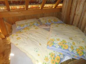 a bed in a wooden room with two pillows at Spaní na seně in Milešín