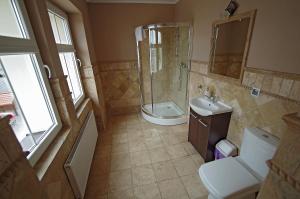 a bathroom with a shower and a toilet and a sink at Młyn Warmiński -Hotelik Hermes in Pieniężno +18 photos
