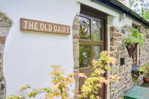 un panneau pour l'ancienne laiterie sur le côté d'un bâtiment dans l'établissement Host & Stay - Dipple Farm Cottage, à Woolfardisworthy 13 autres photos