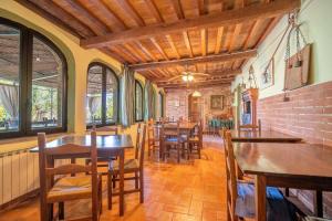 a dining room with tables and chairs and windows at Il Castagneto Country Retreat in Pozzuolo