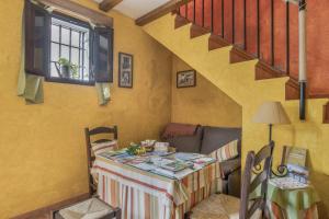un salon avec une table et un escalier dans l'établissement Casa de Bárbara, à Alcalá de los Gazules