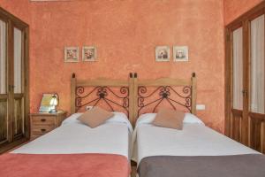 - 2 lits dans une chambre aux murs orange dans l'établissement Casa de Bárbara, à Alcalá de los Gazules