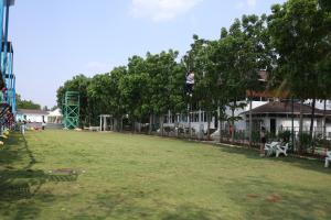 a person is hanging from a tree in a park at Gubbi Goodu Green Resort in Bangalore +71 photos