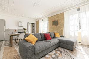 a living room with a gray couch and a table at iFlat Historical Luxury Apartment San Luca 11 A in Genova