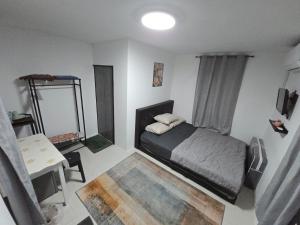 a bedroom with a bed and a table and a mirror at Amsyah Roomstay in Pendang