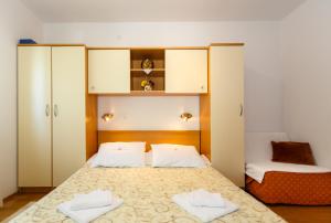 sypialnia z łóżkiem i dwoma ręcznikami na nim w obiekcie Villa Rosi w Krku