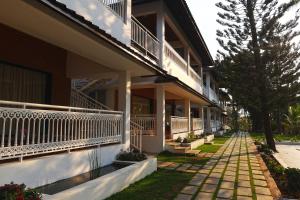 a building with a walkway in front of it at Gubbi Goodu Green Resort in Bangalore