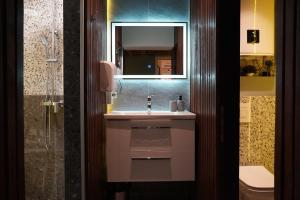 a bathroom with a sink and a mirror at Apartments Guinness in Sarajevo +27 photos