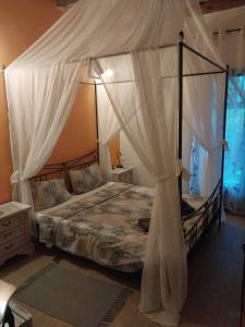 a bedroom with a canopy bed with white curtains at Castelo 2025 in Vrnjačka Banja