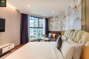 a bedroom with a large bed and a large window at Apec Mandala Wyndham Mui Ne Ngoc Linh in Mui Ne