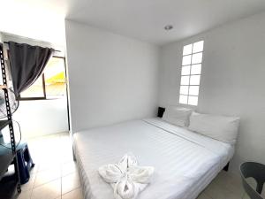 a bedroom with a white bed with a flower on it at Patong Canal Villa R200 in Patong Beach +6 photos