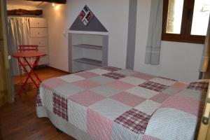 1 dormitorio con 1 cama con manta a cuadros en L'oustal Les Fayards, en Meyrueis