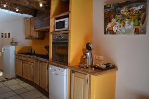 cocina con nevera blanca y microondas en L'oustal Les Fayards, en Meyrueis