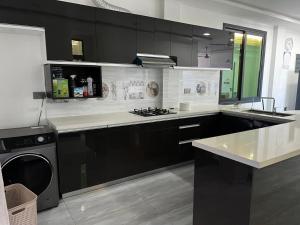 a kitchen with black and white cabinets and a dishwasher at Quest by Entrance in Feydhoo