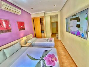 ein Schlafzimmer mit zwei Betten und einem Flachbildfernseher in der Unterkunft Luz Madrid Rooms in Madrid