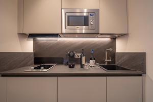 eine Küche mit Spüle und Mikrowelle in der Unterkunft Monolocale San Pietro in Assisi + 3 Fotos