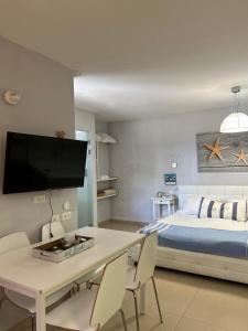 Un dormitorio con una cama y una mesa con sillas. en סוויטות ריילי, en Had Nes