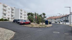 ein rotes Auto, das am Straßenrand geparkt ist in der Unterkunft Ericeira Breeze Villa in Ericeira