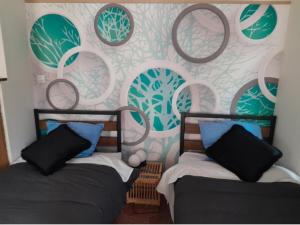 a bedroom with two beds and a wall with circles at LA Coloc in Gournay-en-Bray +15 photos