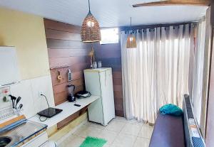 a small kitchen with a refrigerator and a table at Chalé Madeira Nobres Asa Própria in Estivado