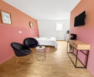 a room with a bed and two chairs in it at Studio lumineux et cosy in Roubaix