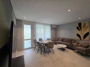 a living room with a couch and a table and chairs at Blue Harmony in Lalzit Bay