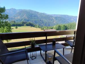 un tavolo e sedie su un balcone con vista sulle montagne di Da NOEMI E MARCO a Cavalese