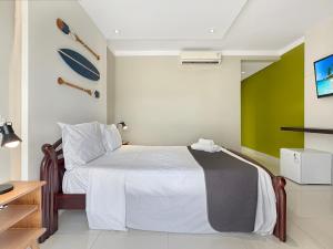 a bedroom with a bed and a green wall at 200m do mar - AC - Piscina - Churrasqueira - 1 Suite in Guarujá +17 photos
